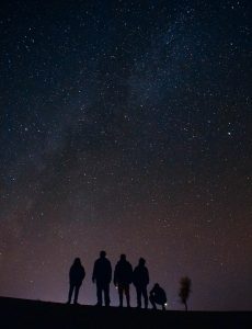 silhouette of five persons staring at the stars at night